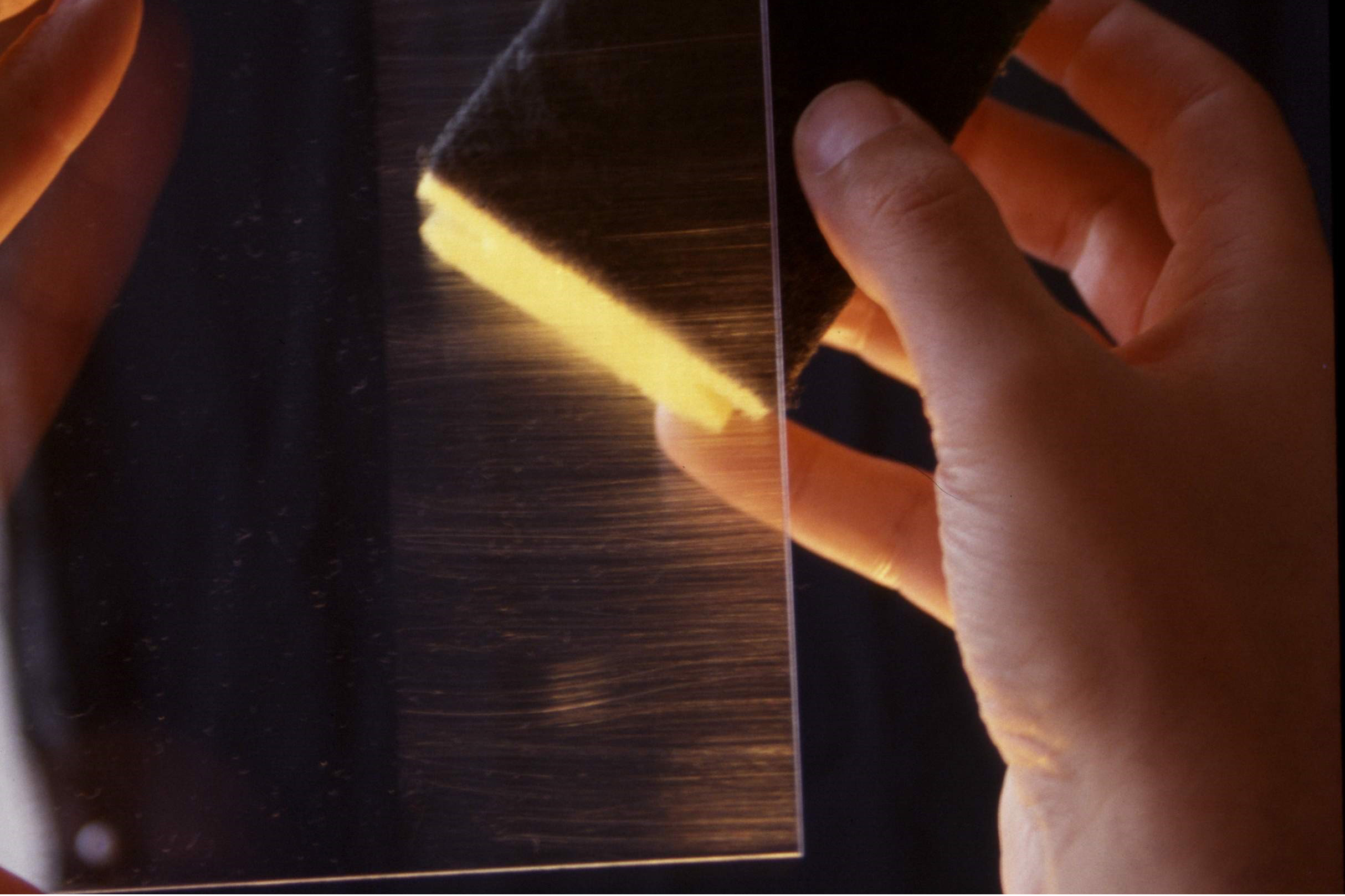 Transparent pane shows scratch marks from a rinsing sponge on the right half, while the left side of the pane shows no scratches due to a scratch protection layer.